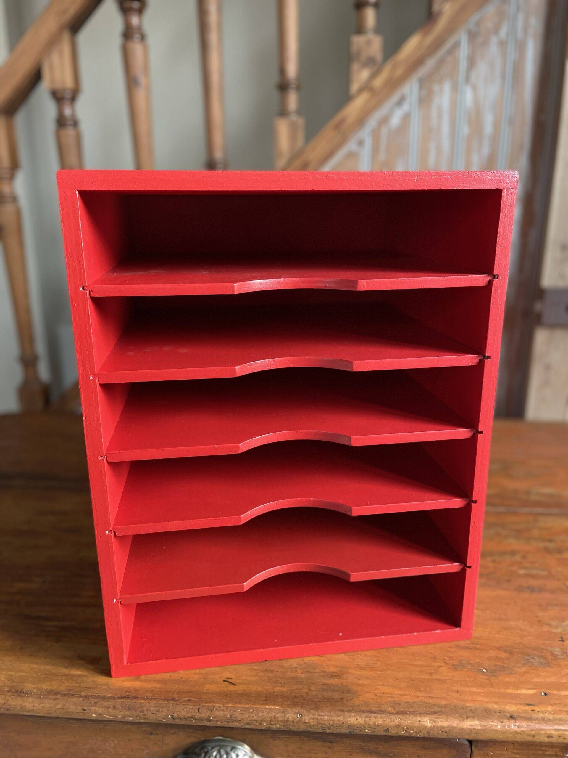 Vintage wooden magazine rack in red.