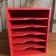 Vintage wooden magazine rack in red.