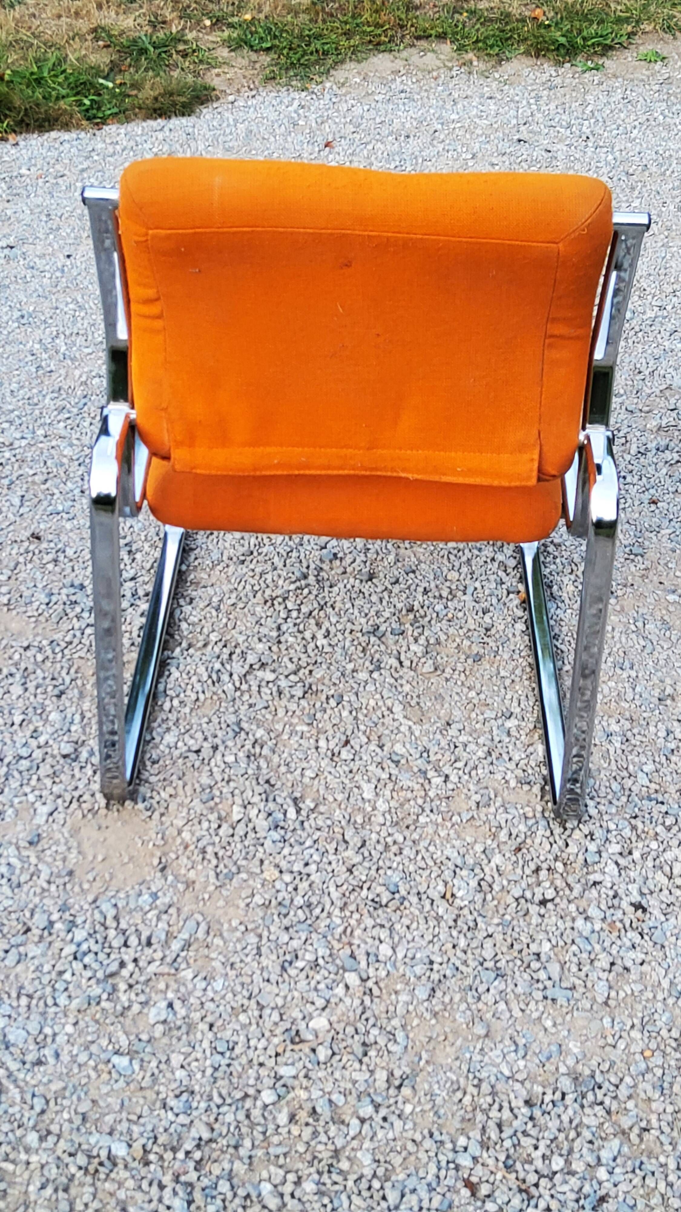 Pair of designer armchairs in orange fabrics and chrome tubes from the 70s