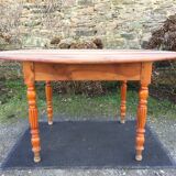 Table ovale ancienne en cerisier à piétement parapluie.