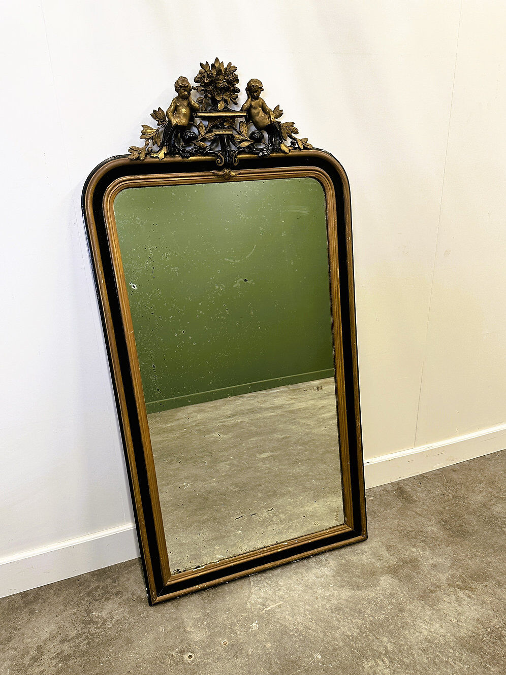 Antique 1800s black and gold mirror with cupid, France 1800s.