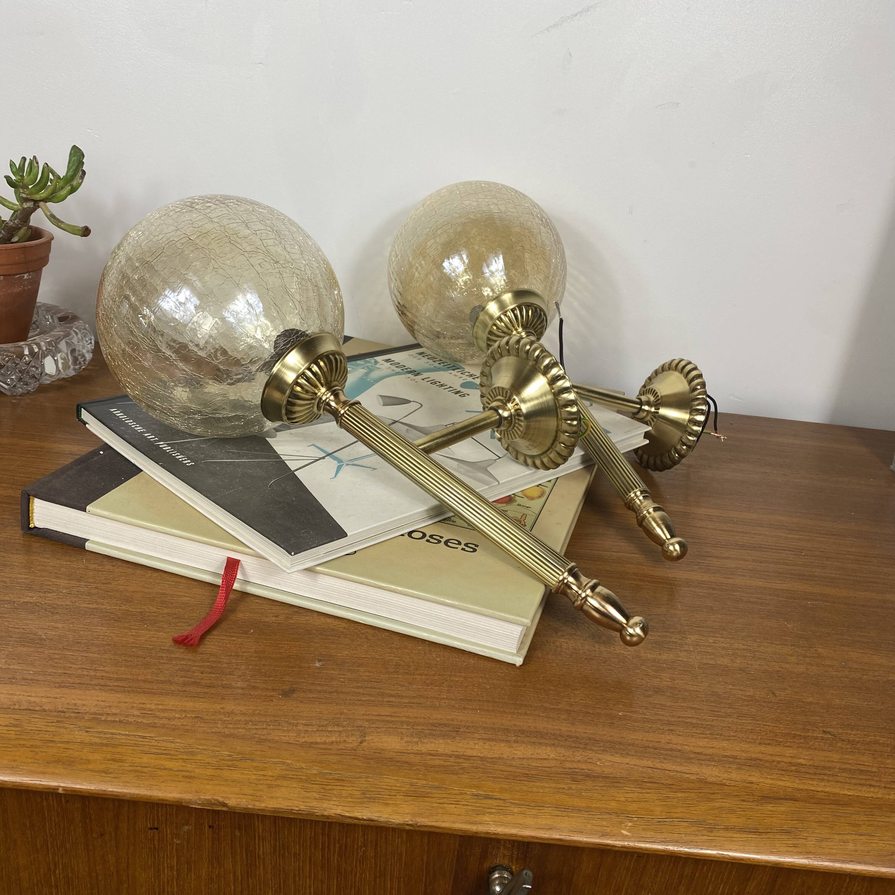 Pair of antique wall sconces torch style brass with glass globes in gold.