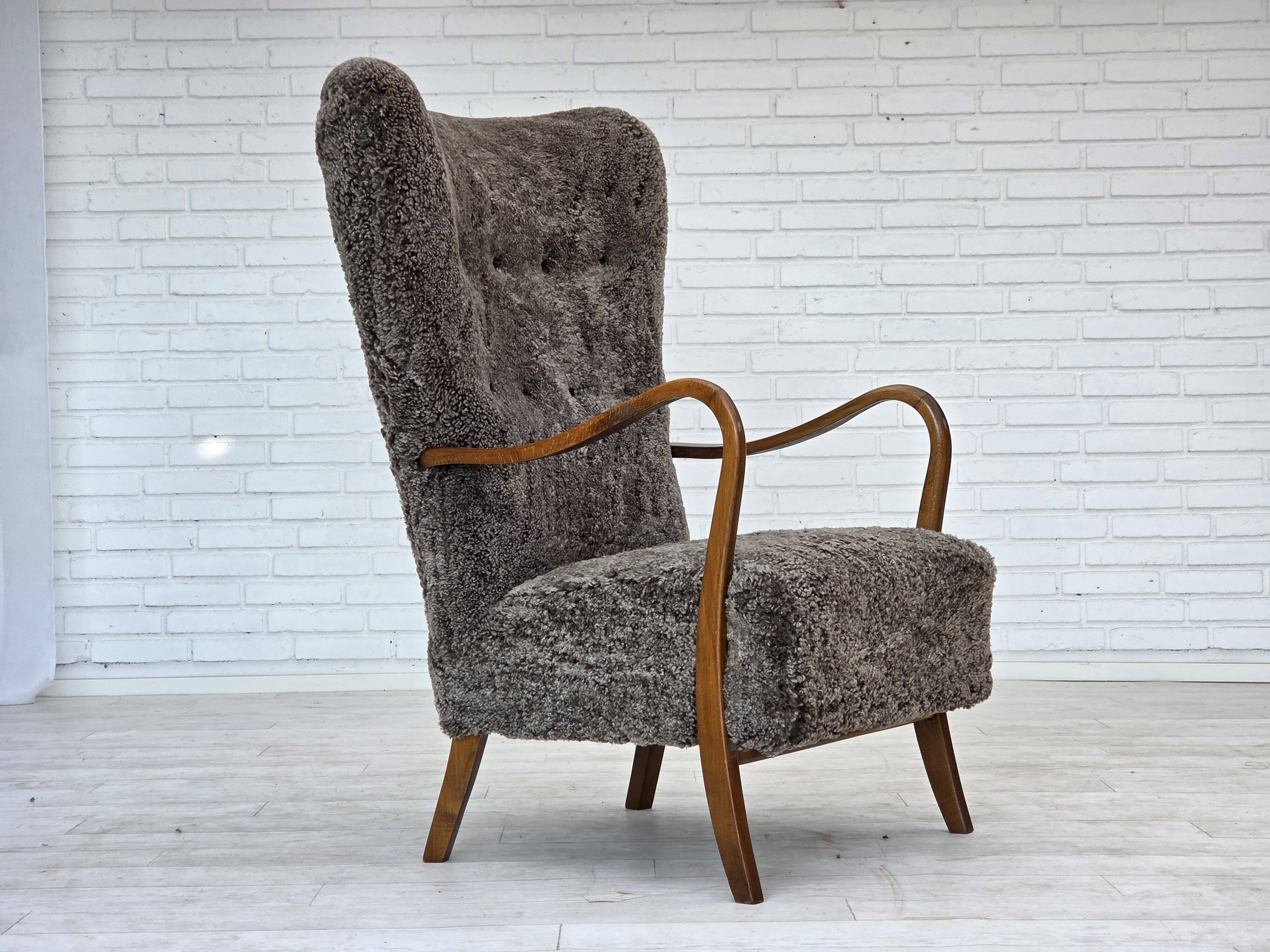 1960s, reupholstered Danish armchair, with stool, genuine sheepskin.