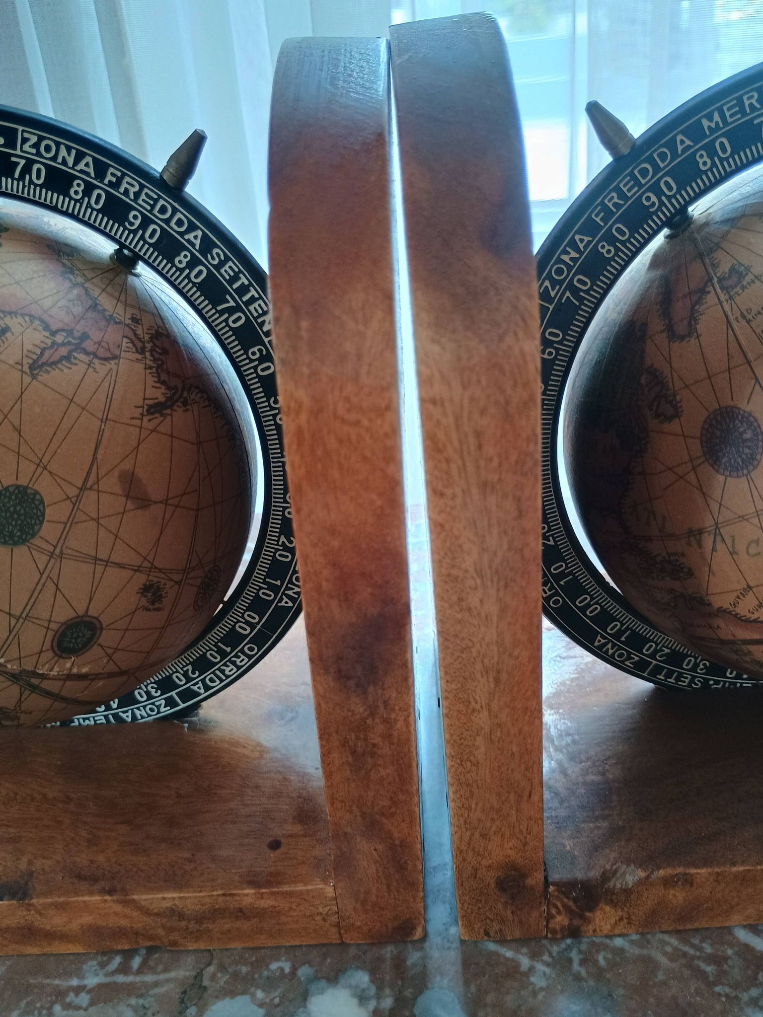 Pair of vintage bookends with rotating terrestrial globes on wooden bases in Spain