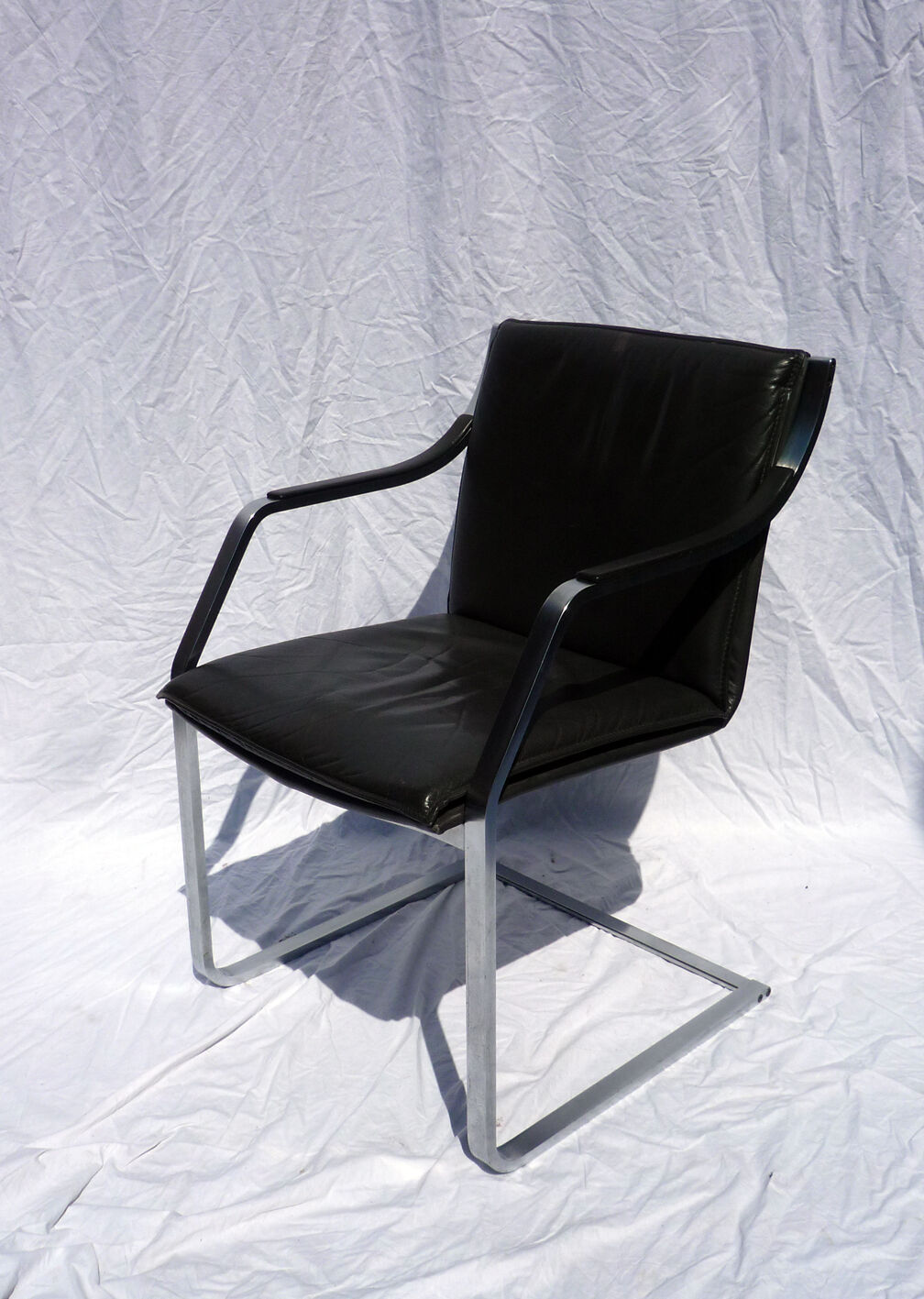 Chair with steel and leather armrests