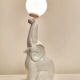 Lampe de table en céramique blanche, éléphant tenant une boule allumée