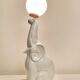 White ceramic table lamp, an elephant holding a lighted ball