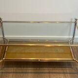 Coffee table in brass, brushed steel, glass, and gilded eglomisé mirror from Maison Jansen.