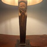 Old lamp with carved wooden base representing a wise man