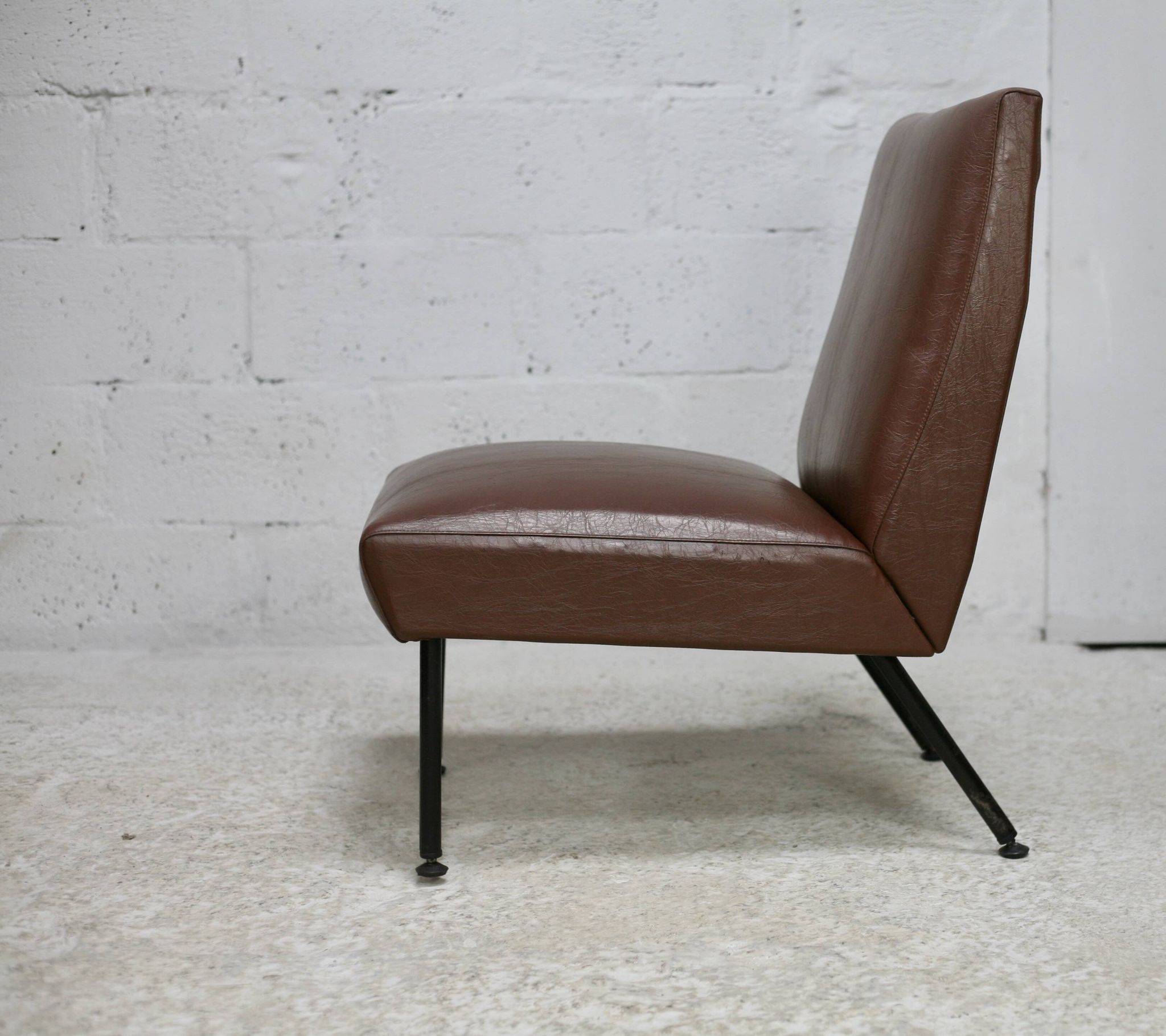 Chauffeuse, circa 1950. Simili-cuir brun.