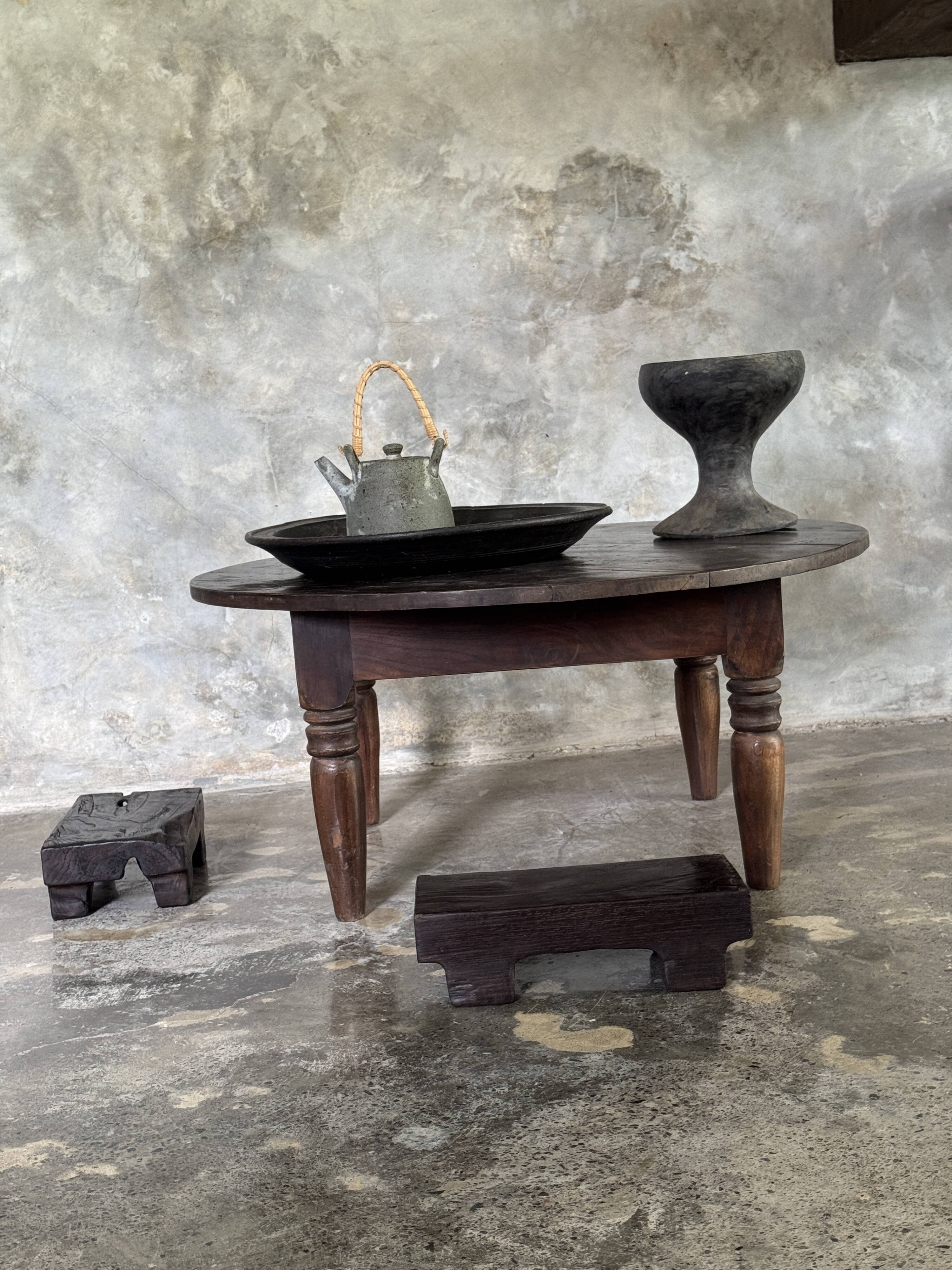 Coffee table, round antique Indonesian teak table with straight legs.