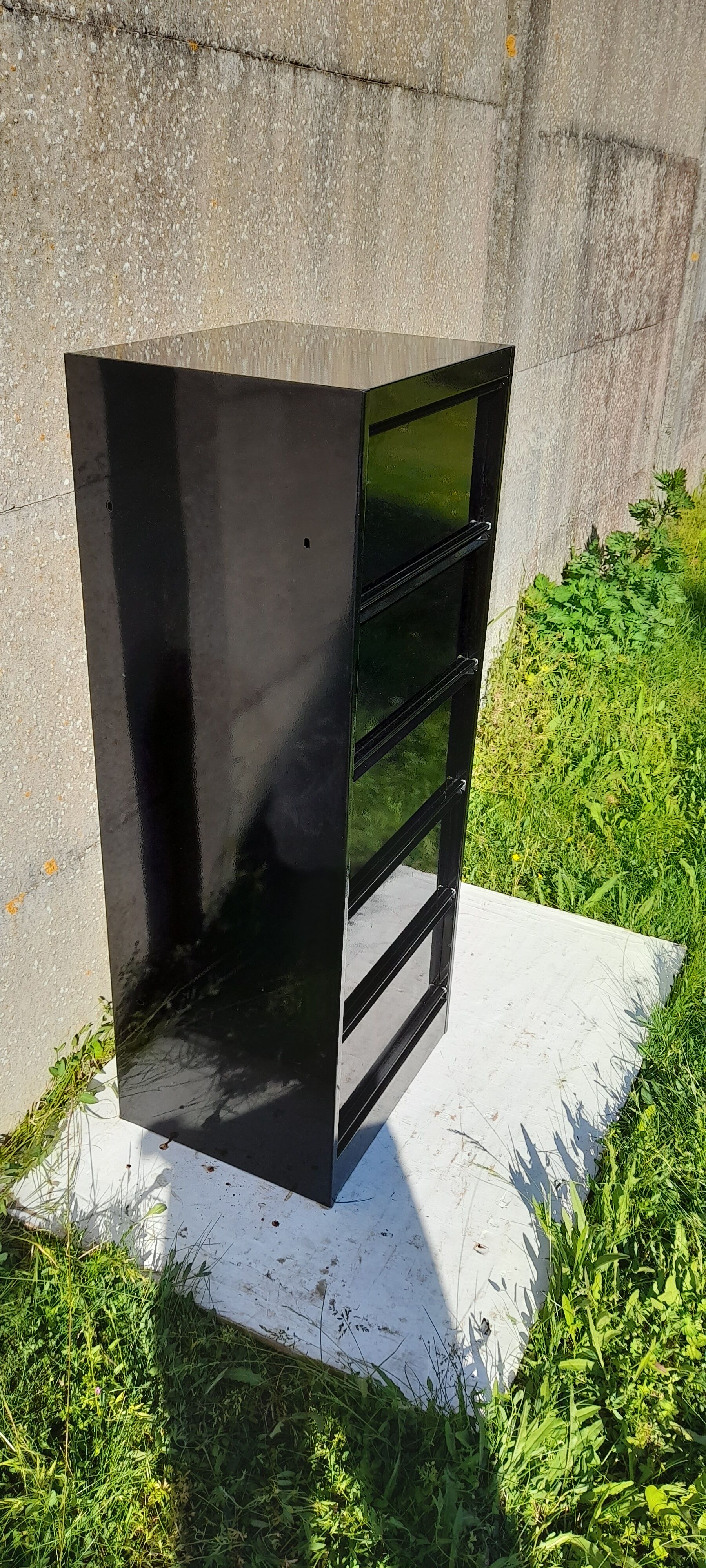 Black metal clamshell cabinet