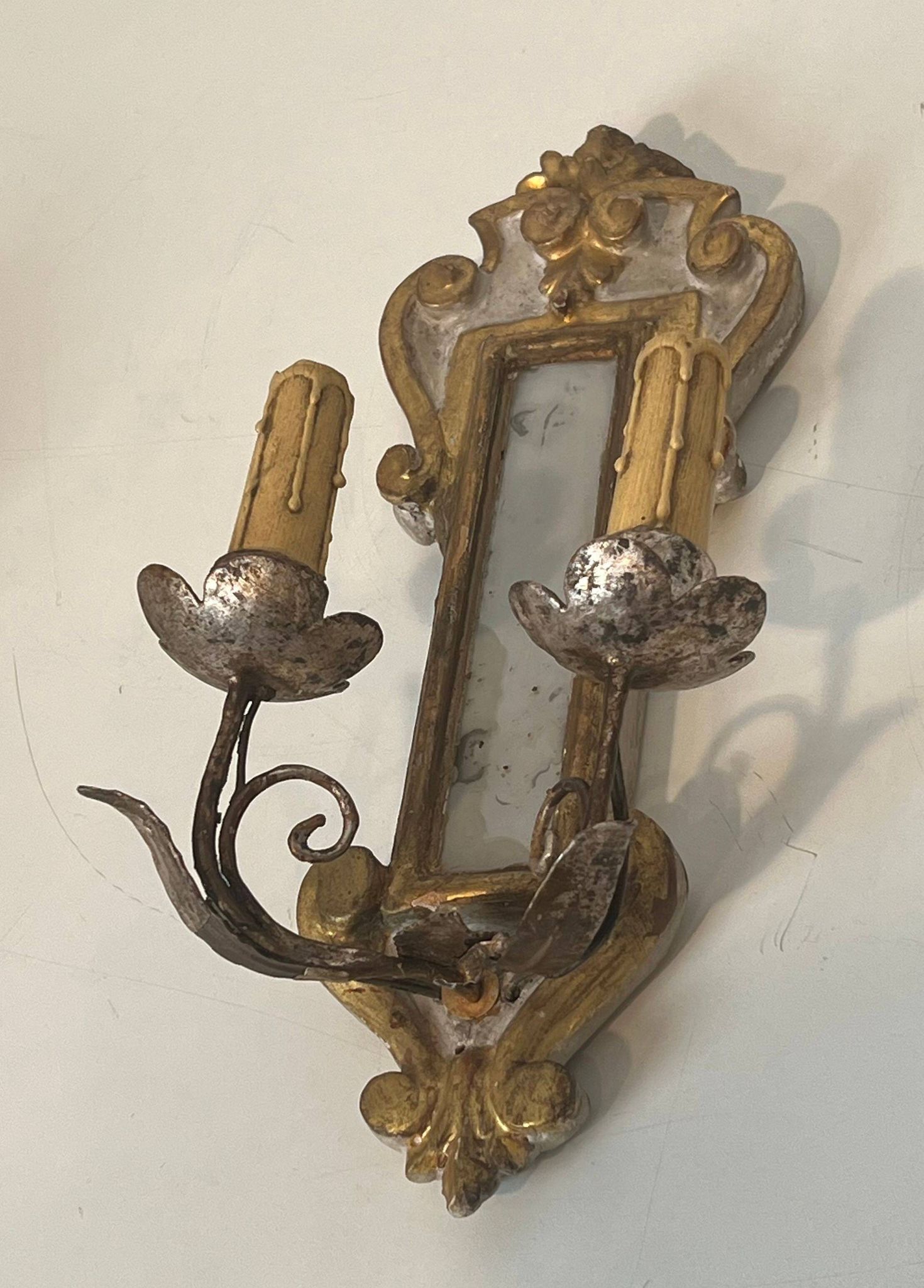Pair of wall sconces in carved wood and silvered and gilded patinated metal with a central mirror.