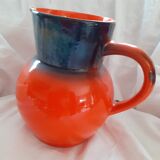 Pitcher in glazed sandstone. orange background and fade colors at the neckline.