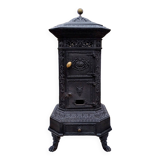 Black cast iron wood burning stove with solid brass handle.