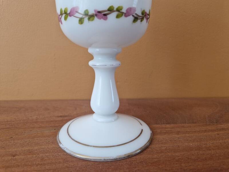 Footed glass in the shape of a chalice in white opaline with a floral decoration.