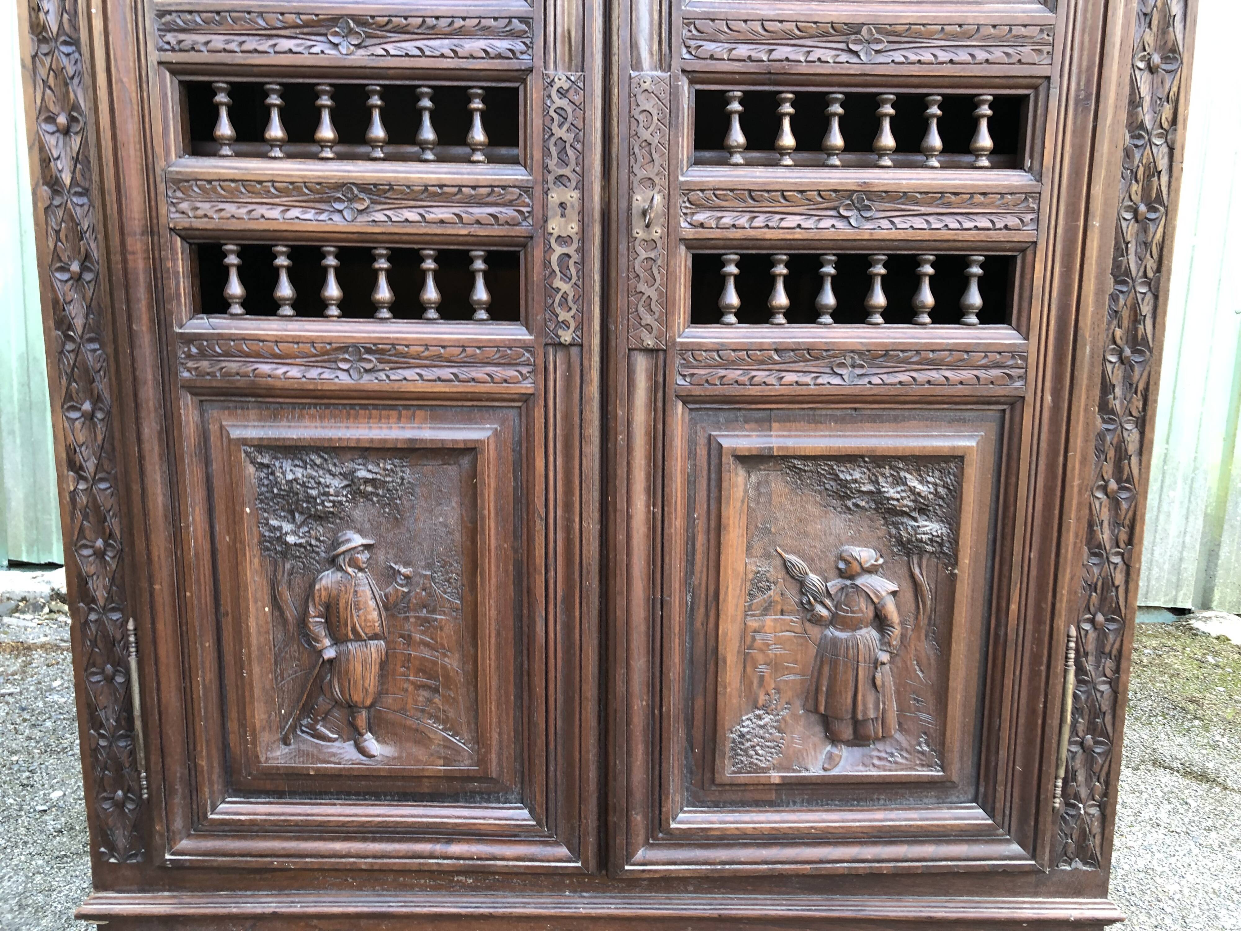 Breton cabinet with carved characters of the early 20th century with 2 doors and 1 oak drawer.