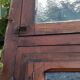Oak entrance door and its frame and transom, wrought iron gates