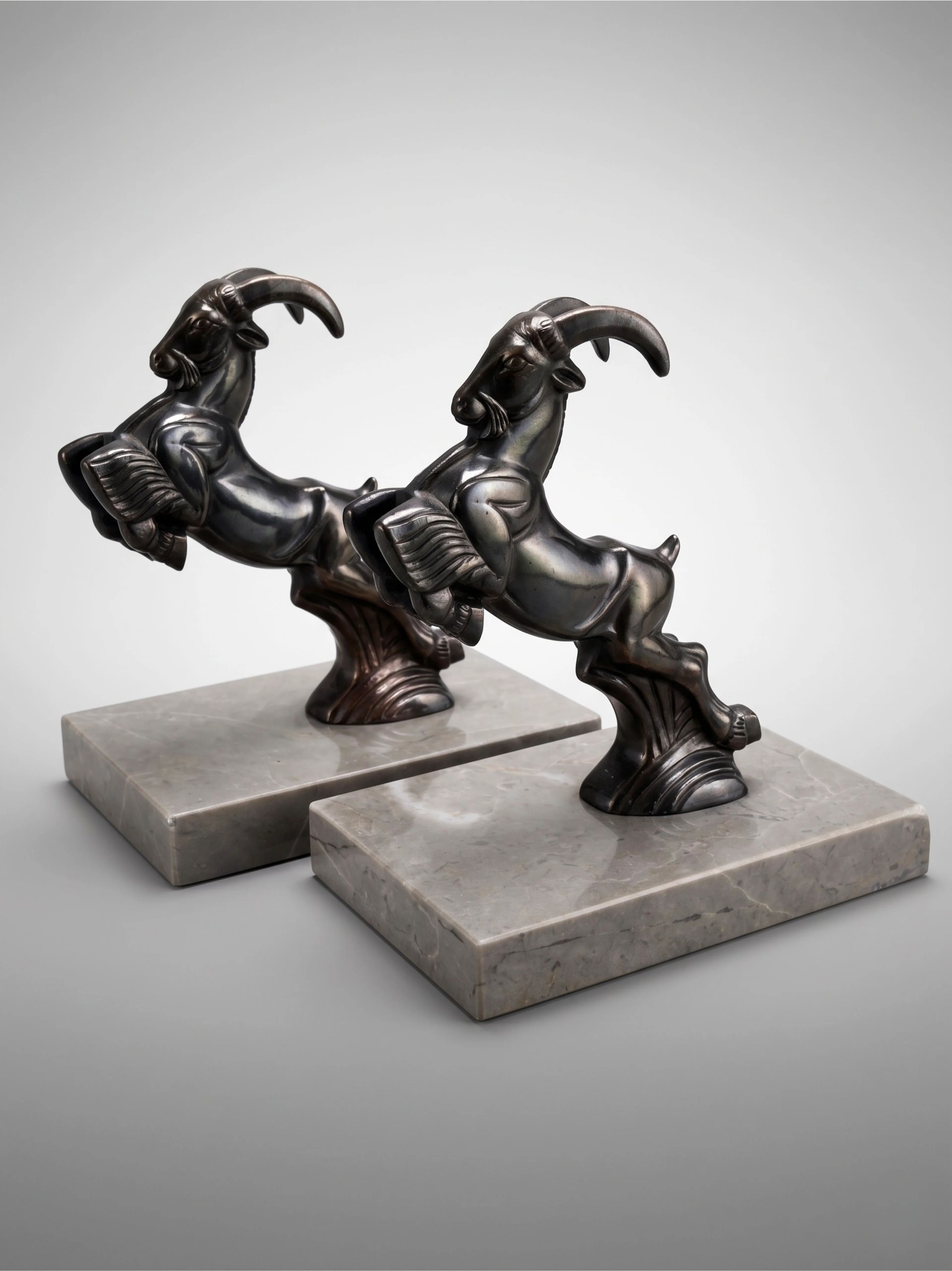 Art Deco bookends with patinated ibex in a taupe marble base.