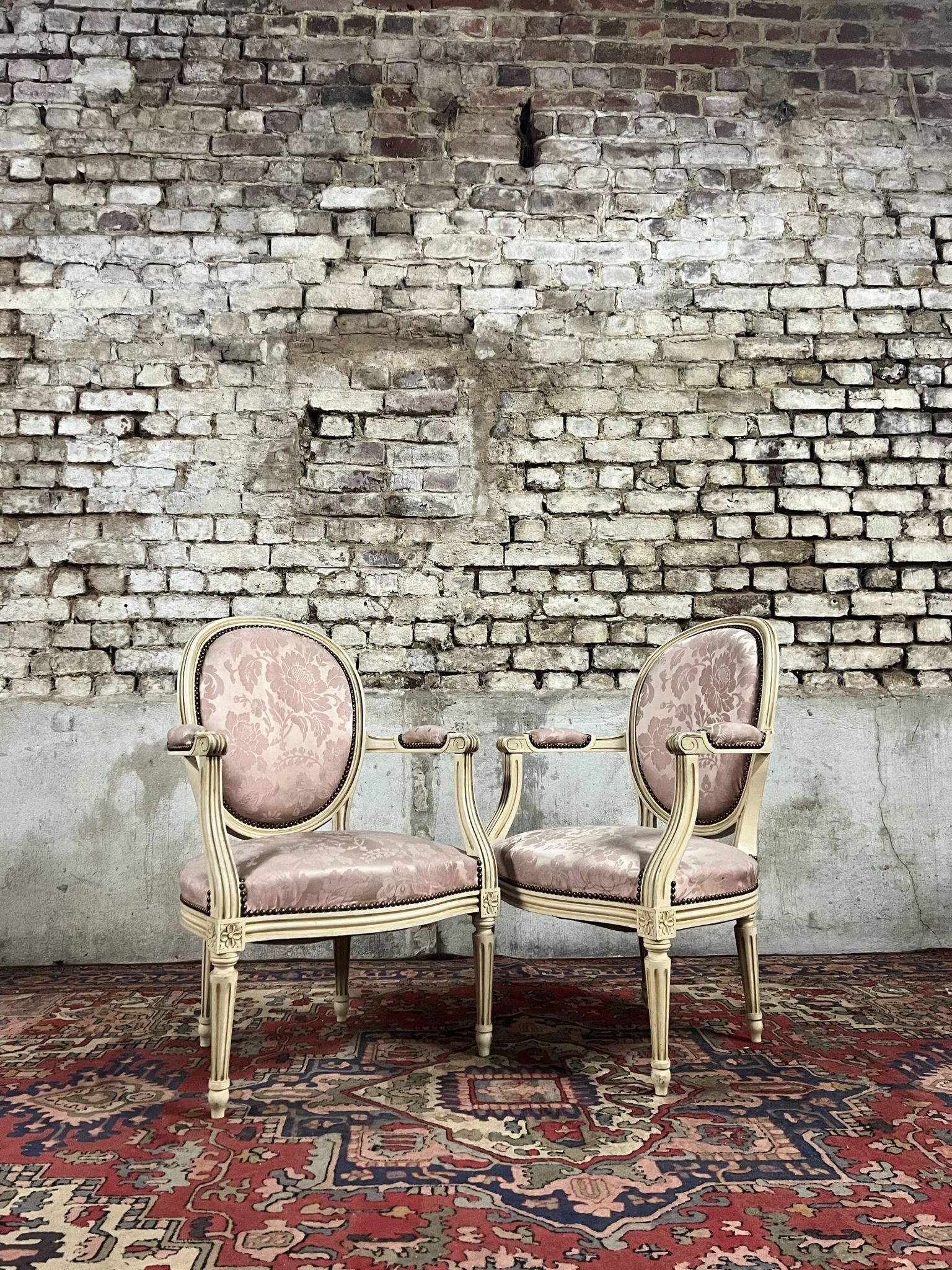 Paire de fauteuils dossier médaillon en bois laqué crème de style louis xvi