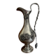 Ewer in pewter surrounded by vine branches with g