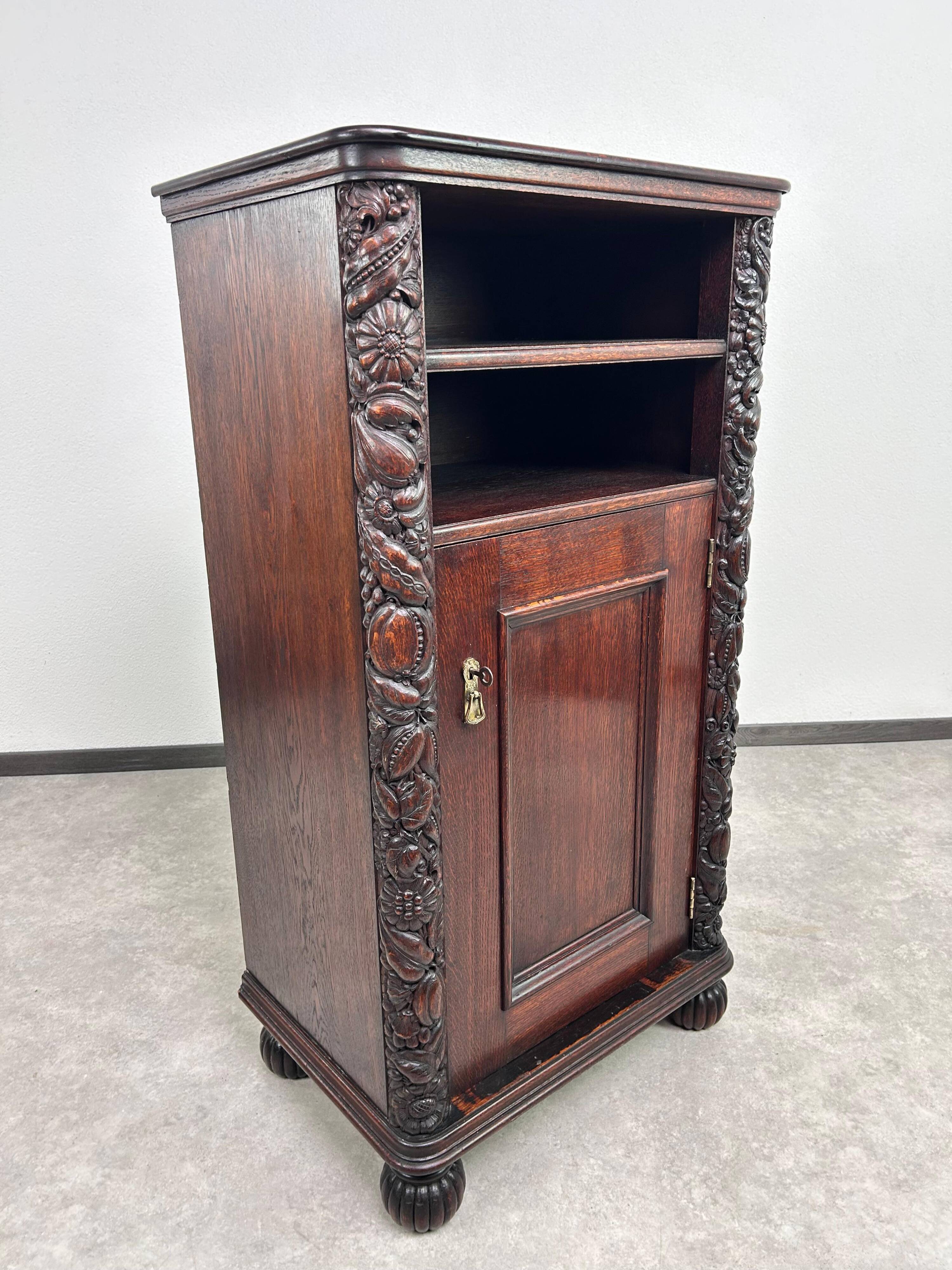Art Nouveau cabinet with a shelf featuring distinctive floral sculptures.
