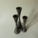 Set of three diabolo-shaped candle holders made of cast steel.