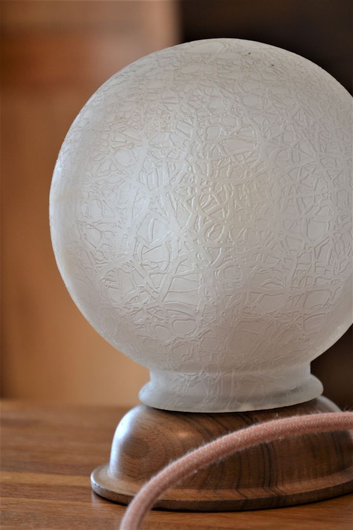 White glass globe table lamp with geometric reliefs
