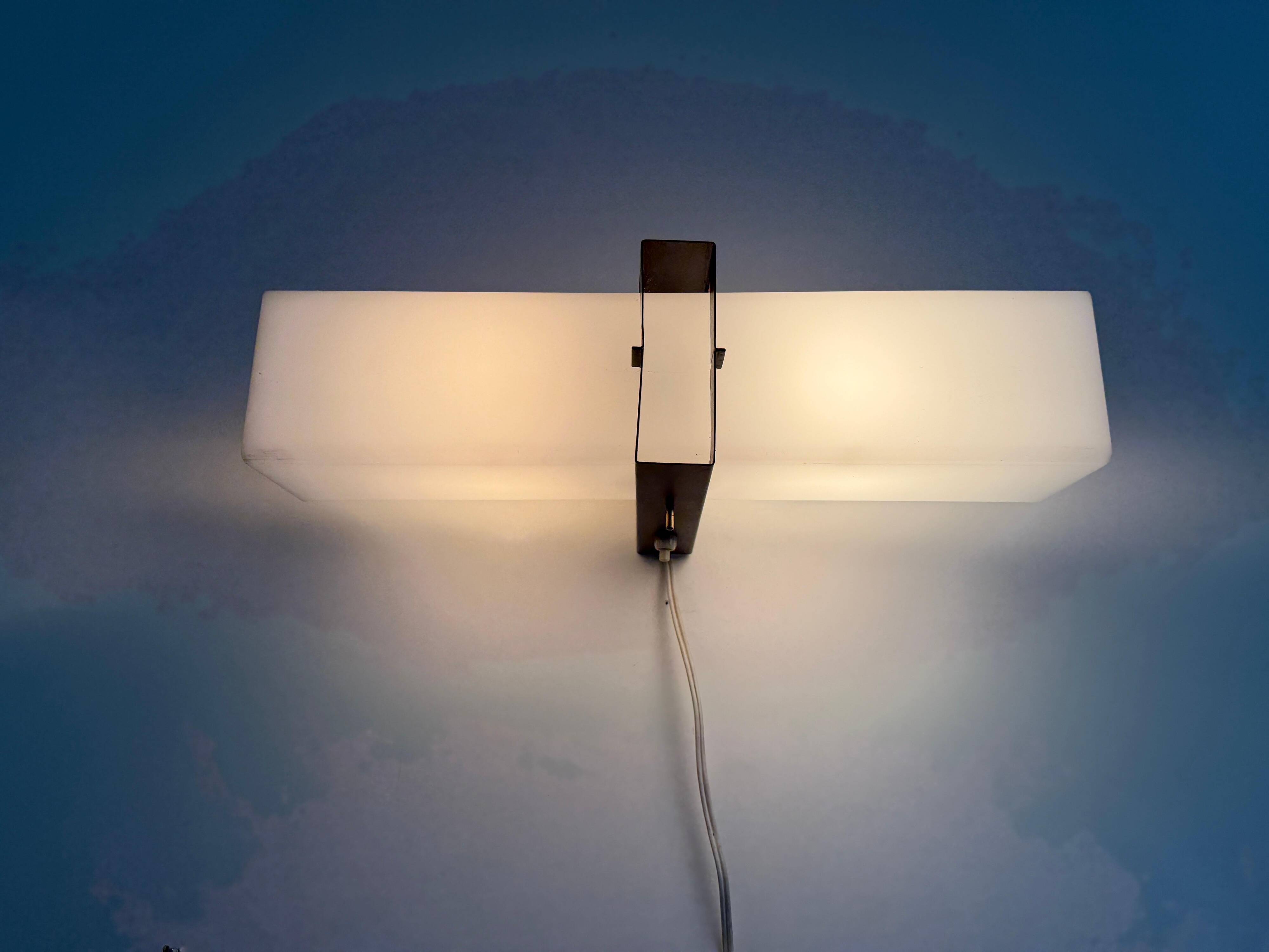 Simple white plexiglass wall light with a black metal frame, 1970s, Germany.