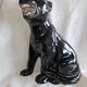 Statue of a roaring panther/leopard sitting in black glazed ceramic.