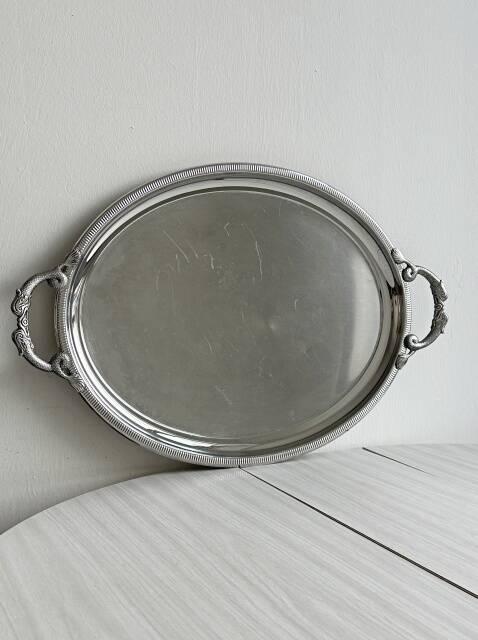 Large stainless steel serving platter with fish-shaped handles.