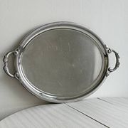 Large stainless steel serving platter with fish-shaped handles.