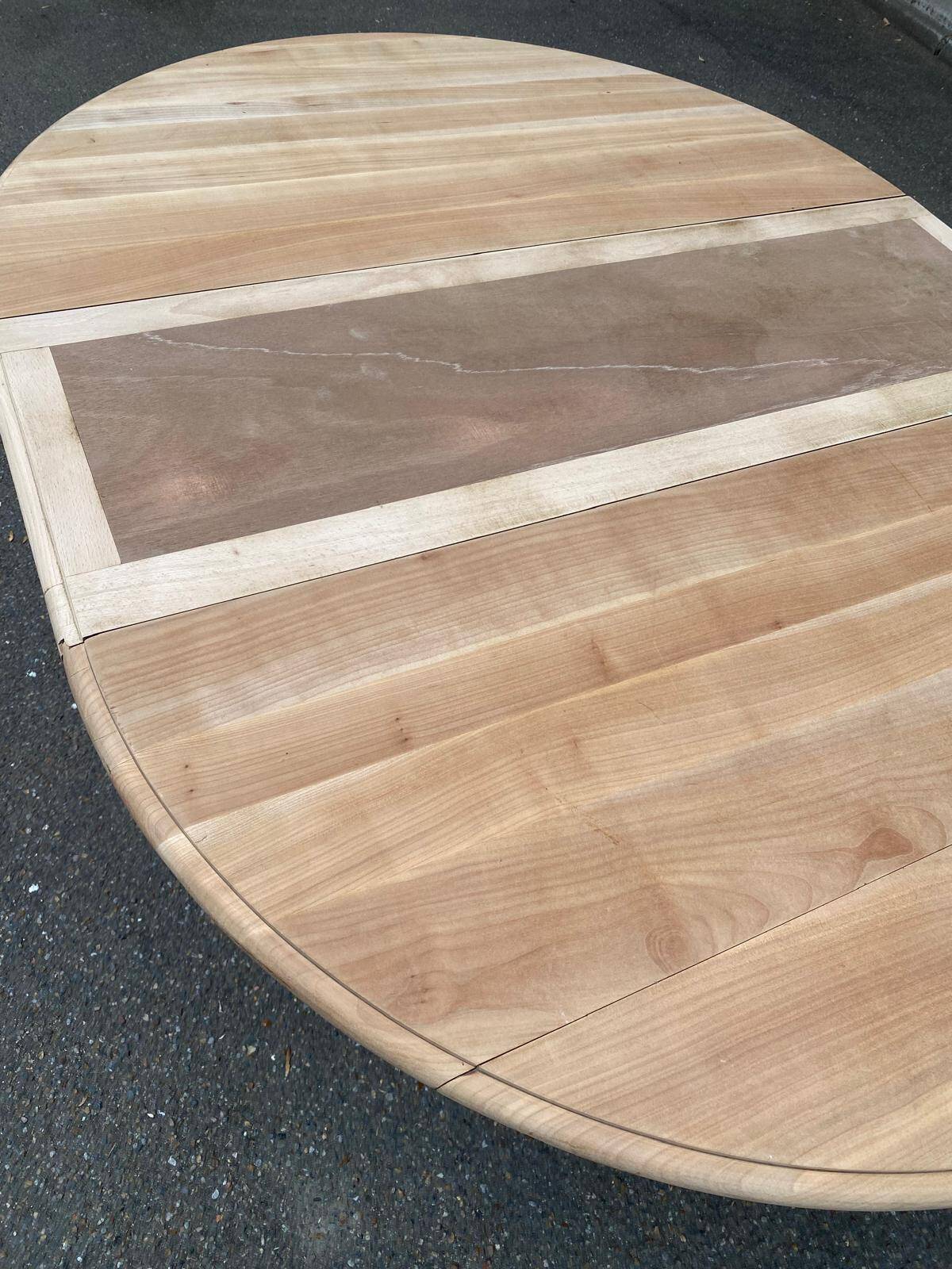Round dining table with a central pedestal, extendable, stripped in solid walnut with 2 extensions.