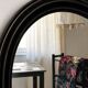 Antique oval mirror in patinated black wood