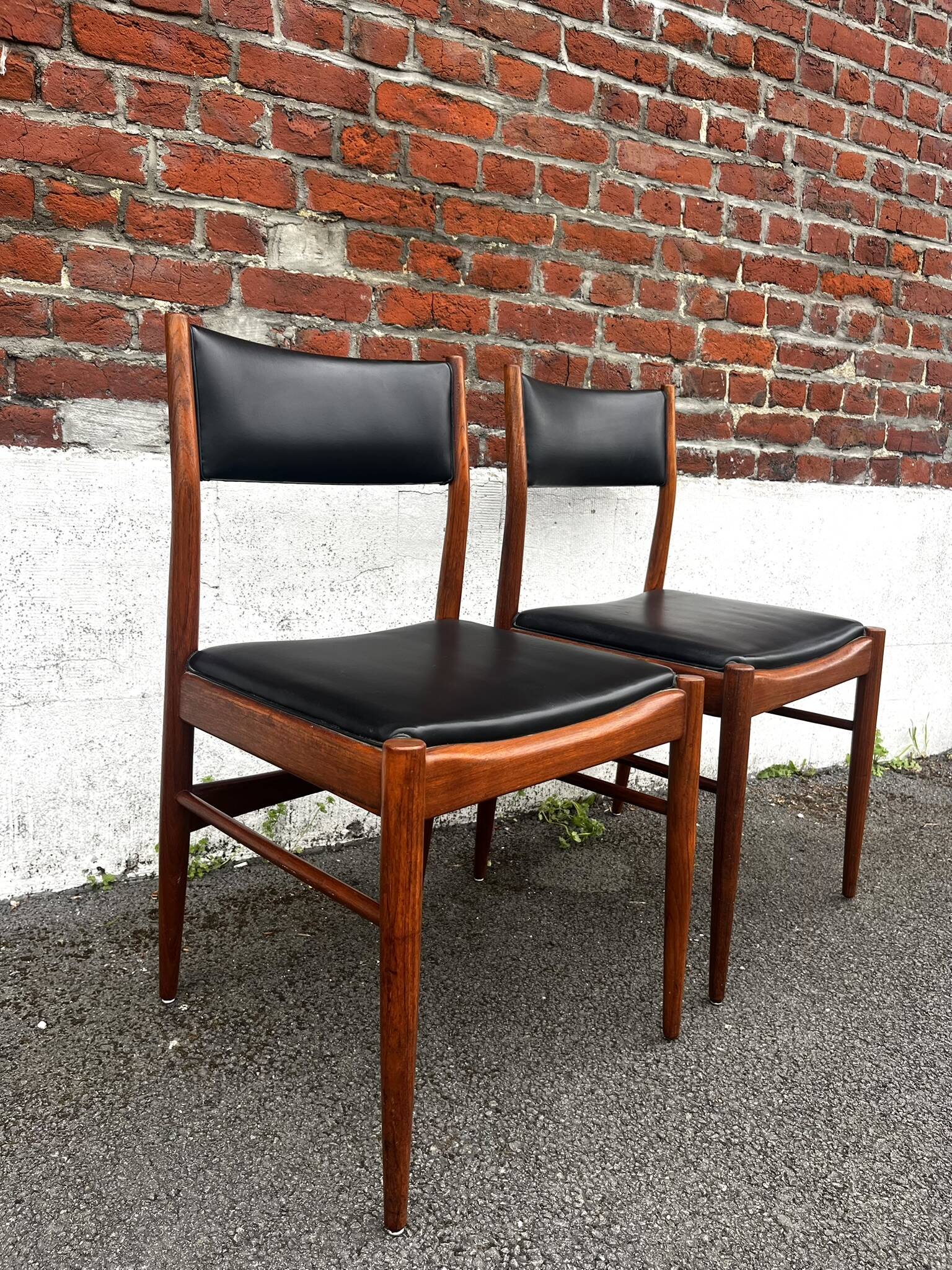 Set of 2 vintage Scandinavian chairs in wood and black faux leather.