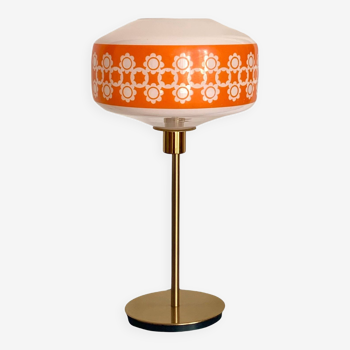 Table lamp with a vintage orange glass globe and a golden foot