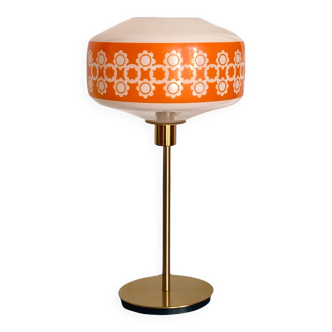 Table lamp with a vintage orange glass globe and a golden foot
