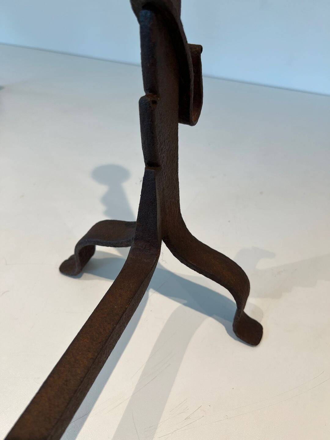 Pair of wrought iron andirons with adjustable supports and tripod feet.