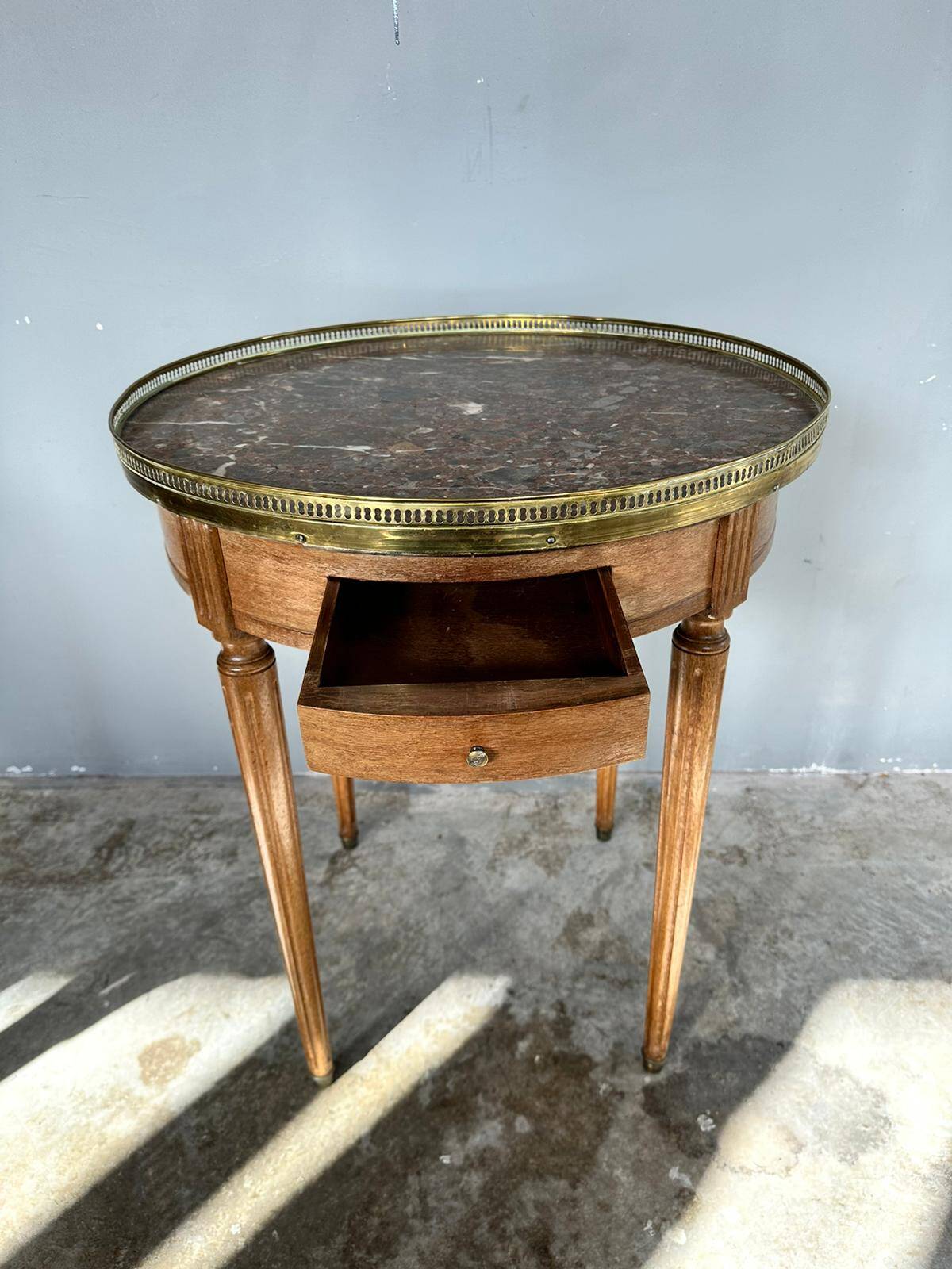 Hot water bottle table with a marble top and a brass gallery.