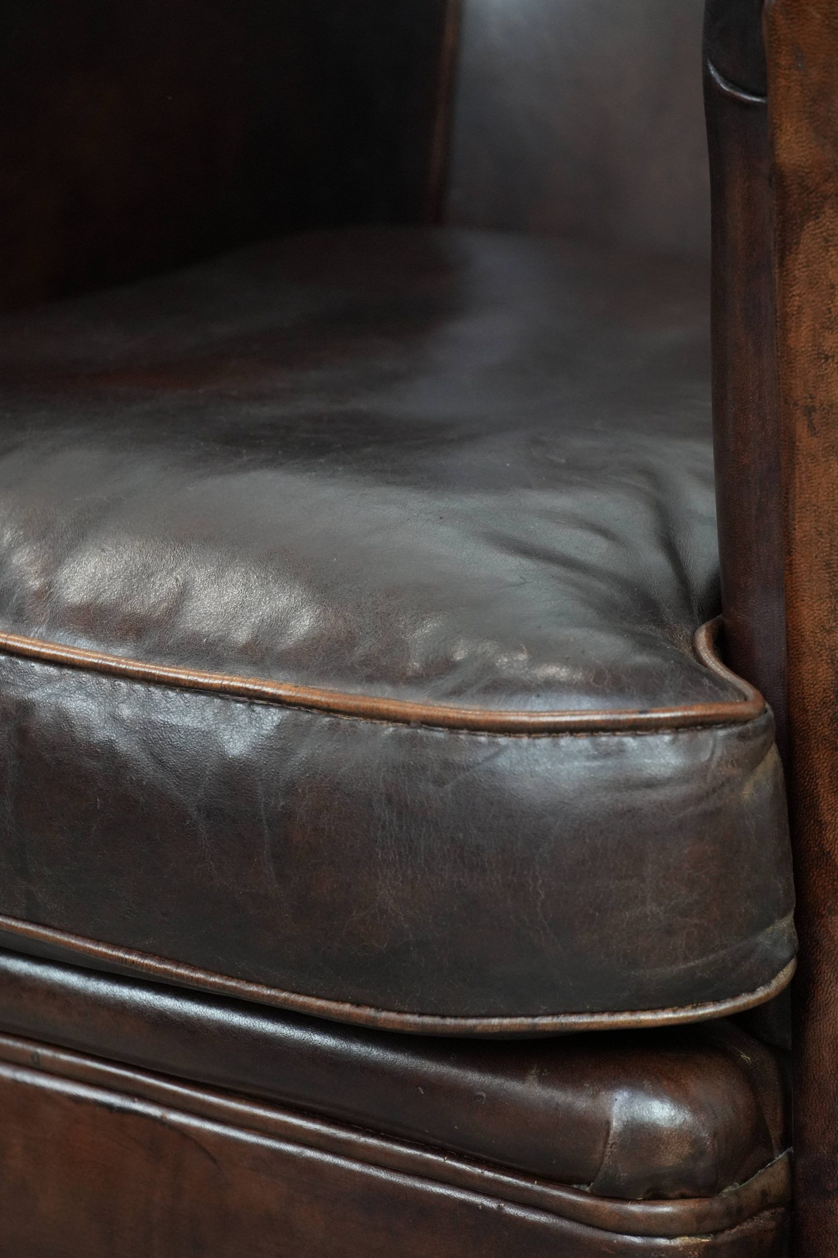 Dark brown vintage club armchair in English style made of sheepskin leather