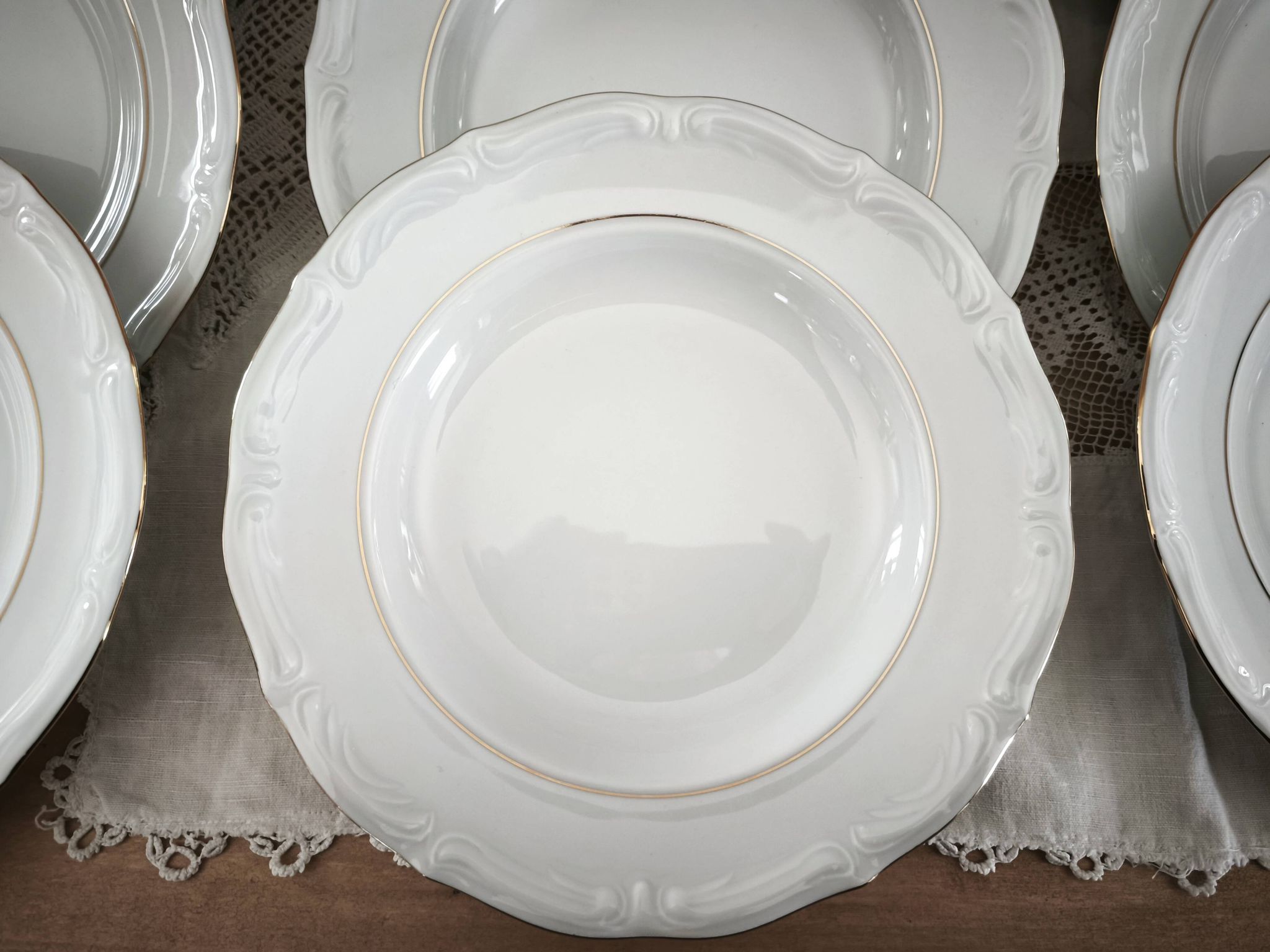 12 deep plates in porcelain with double gold trim.