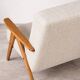 Mid-century modern armchair in solid wood and light beige fabric.