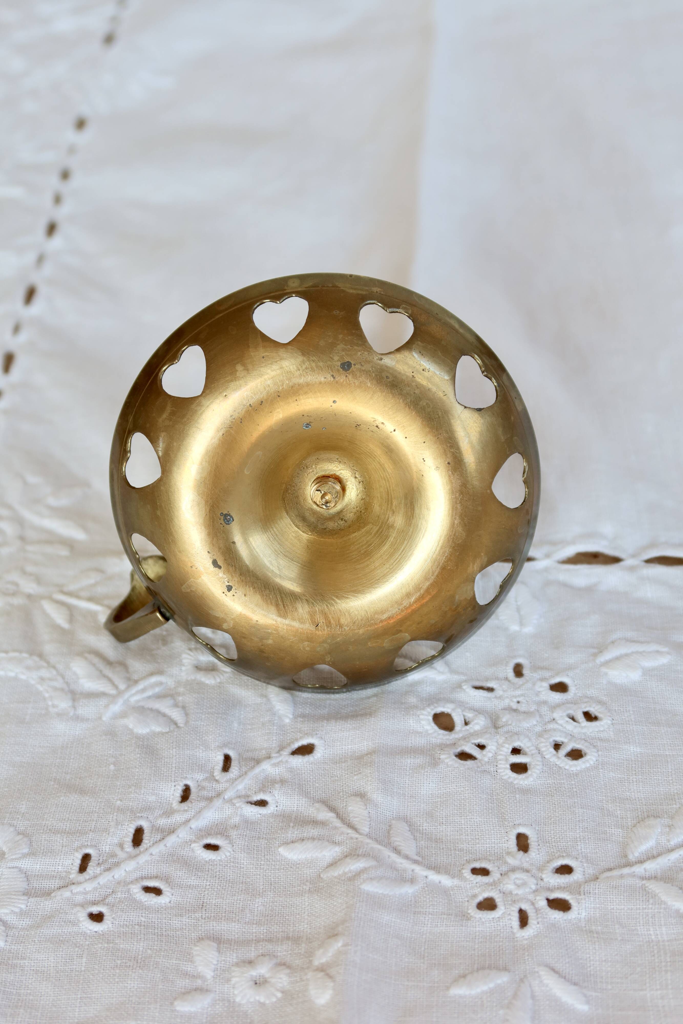 Antique brass rat trap with heart patterns.