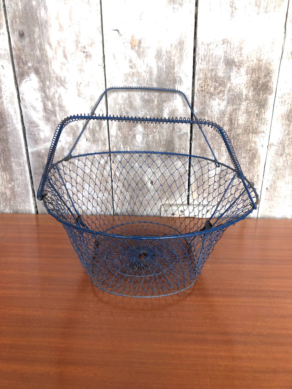 Old foldable blue metal basket, vintage handles