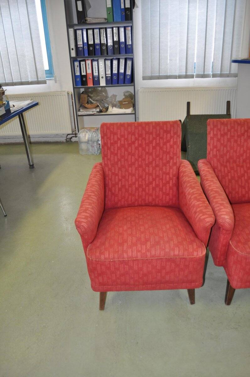 Pair of Mid-Century armchairs in red and brown fabric with dark wooden legs.