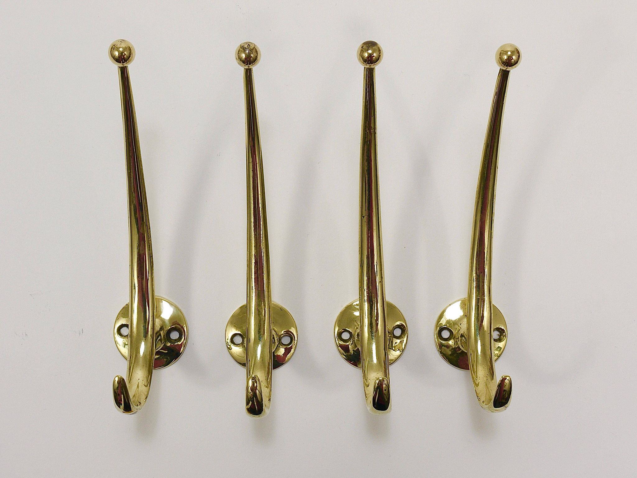 Two curved wall coat racks in brass by Franz Hagenauer, Vienna, mid-20th century, 1950s.