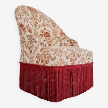 Beige toad armchair with floral patterns and red fringes