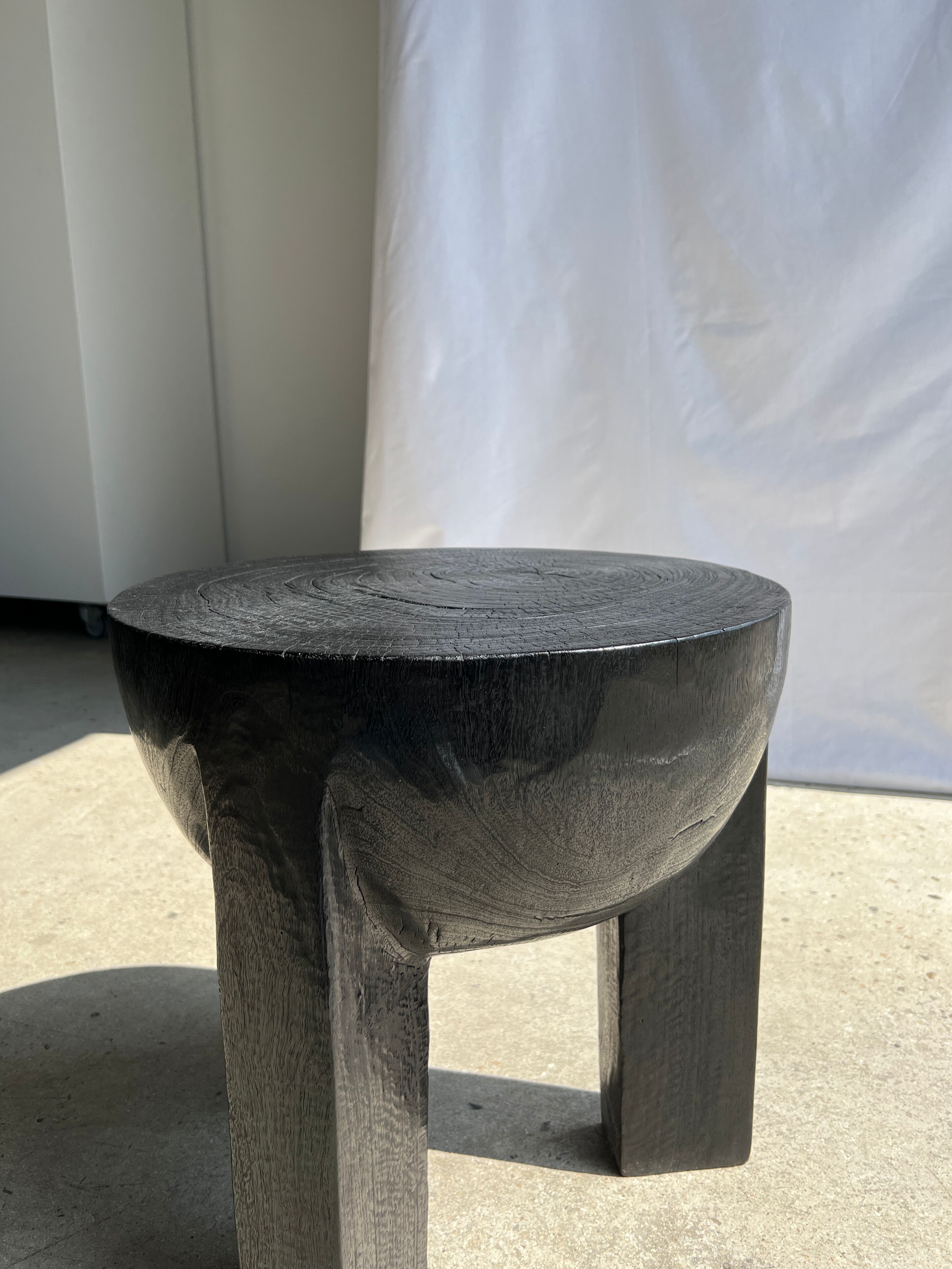 Black mango wood tripod side table with a semi-spherical top, height: 45 cm, diameter: 44 cm.