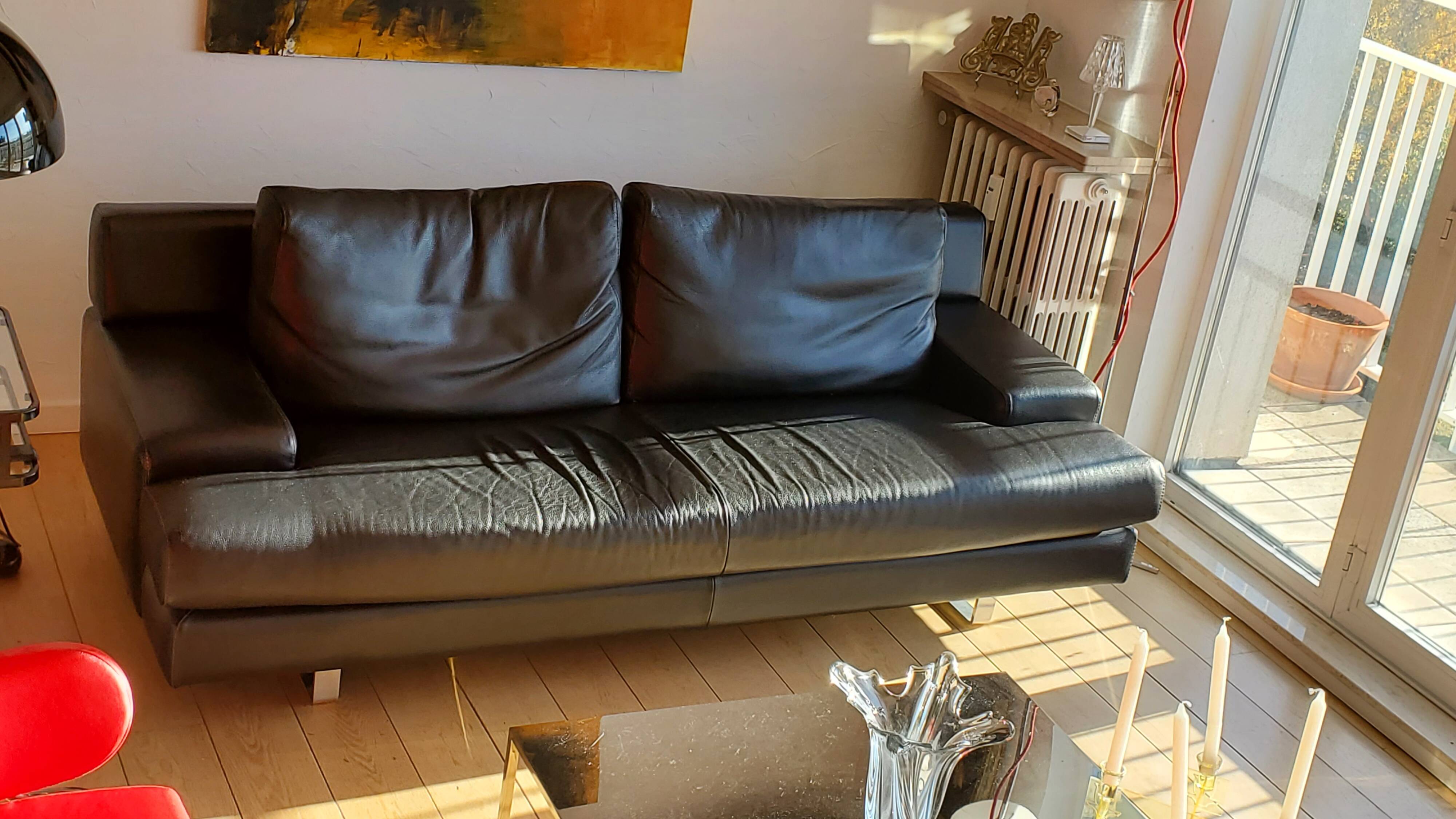 Black leather three-seater sofa