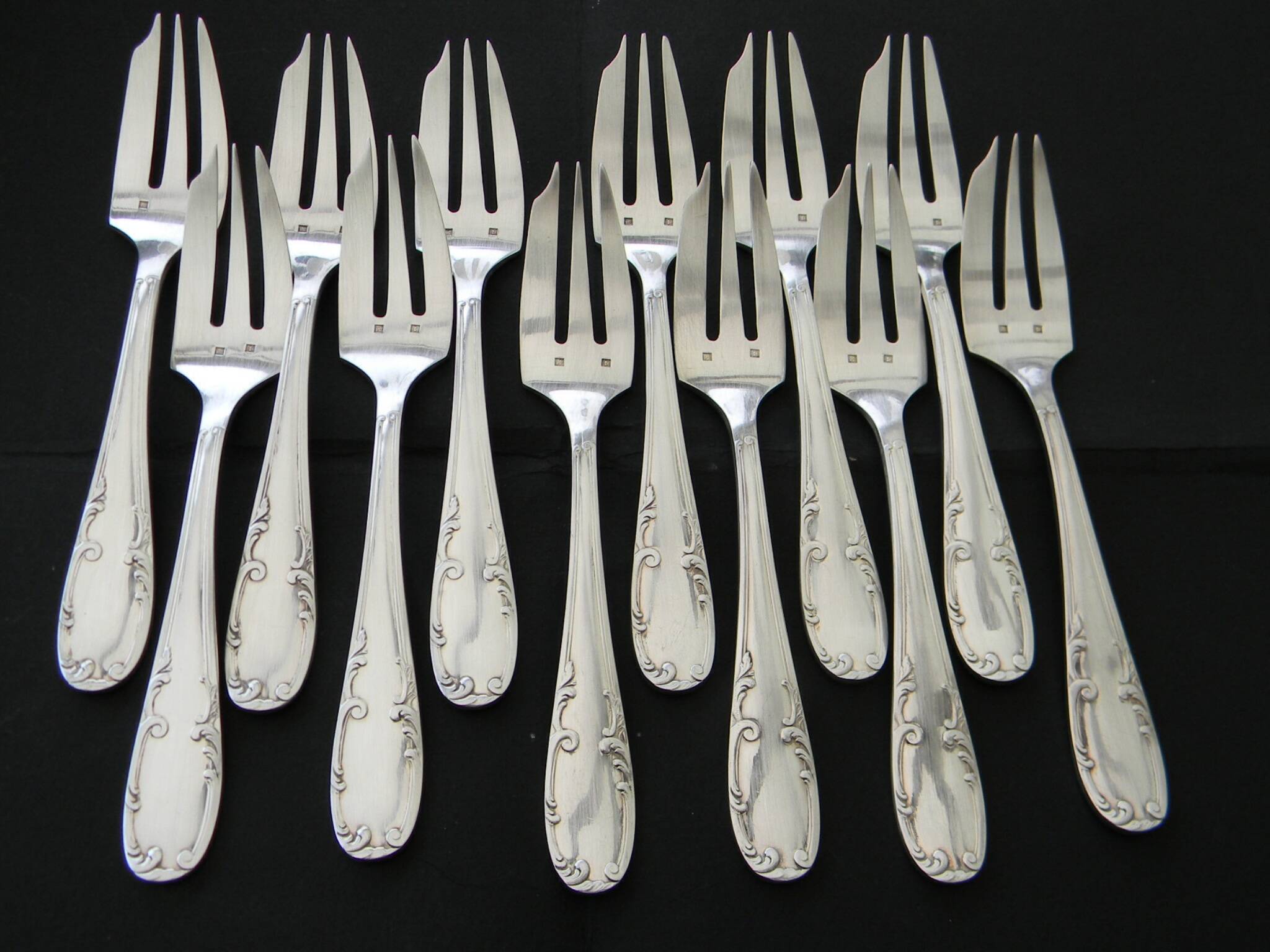 12 cake forks and a silver metal server.